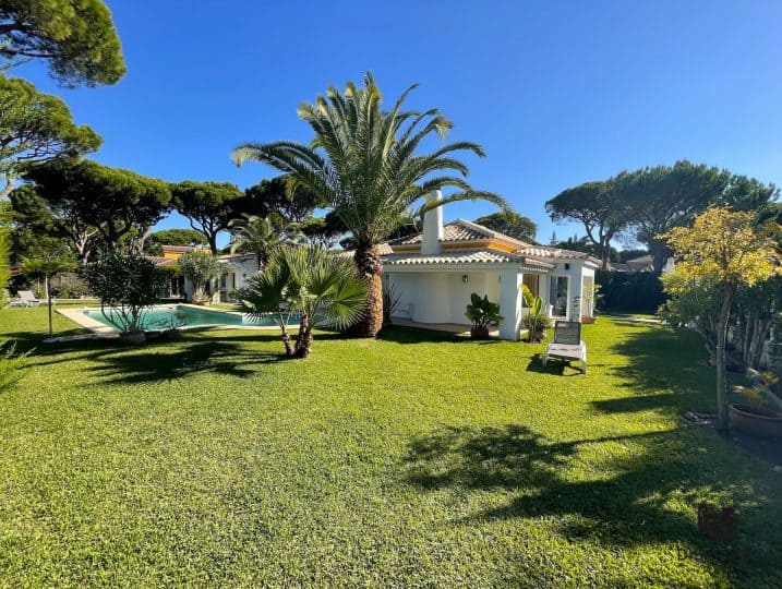 Vista lejana sobre el jardín de la casa y la piscina - Villa Alondra